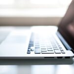 Free Elegant side view of a laptop on a glossy table with natural lighting indoors. Stock Photo